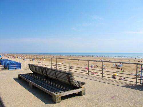 una panchina sulla spiaggia con vista sulla spiaggia di Propriete de 3 chambres avec piscine partagee terrasse amenagee et wifi a Saint Jean de Monts a 2 km de la plage a Saint-Jean-de-Monts