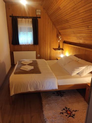 1 dormitorio con 1 cama grande y techo de madera en Kuća za odmor Iva en Lič