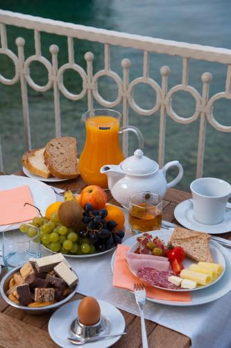 a table topped with plates of food and fruit at Hotel Sunceva Postelja Brela in Brela