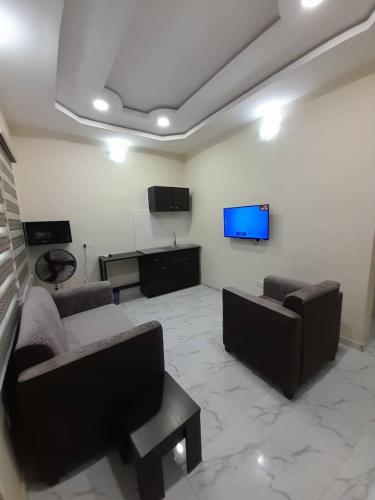 salon z kanapami i telewizorem z płaskim ekranem w obiekcie F and B serviced apartment Abeokuta w mieście Aro