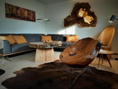 ein Wohnzimmer mit einem blauen Sofa und einem Tisch in der Unterkunft Vey'nes Ferienhaus & Vey'ne Ferienwohnung in Wüstensachsen