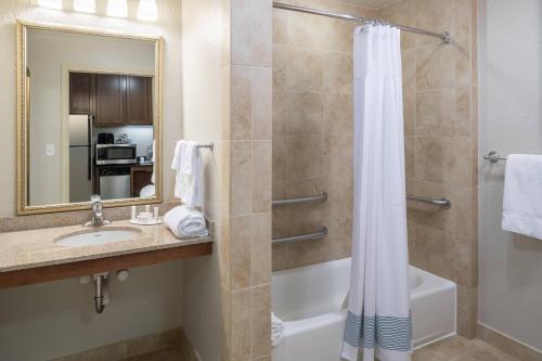 een badkamer met een douche, een wastafel en een bad bij TownePlace Suites Fort Worth Downtown in Fort Worth