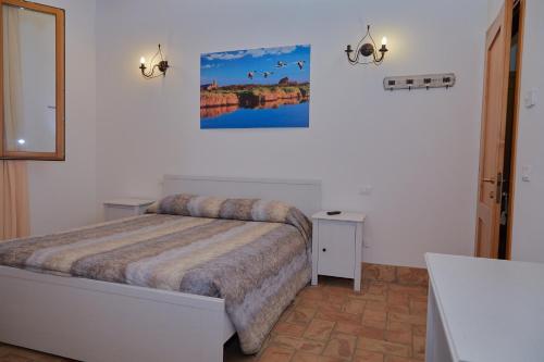 1 dormitorio con 1 cama y una pintura en la pared en La botta vecchia - Delta of the Po - Private parking, en Porto Viro