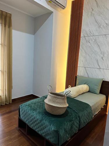 a bedroom with a bed with a basket on it at Villa Magnifica by REQhome in Ciater-hilir