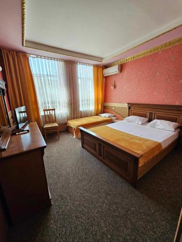 a hotel room with a large bed and a desk at Hotel Izvora in Ruse