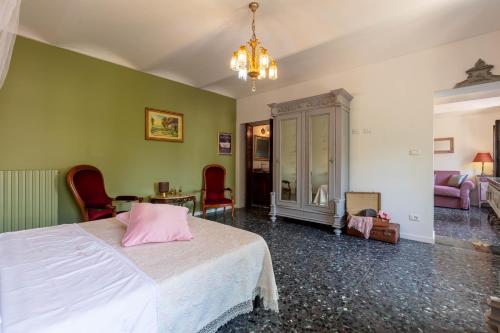 a bedroom with a bed with a pink pillow on it at Piemonte Country House in Agliano Terme