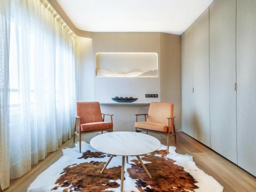 a living room with a table and two chairs at H&ocirc;tel Le Pr&eacute; Carr&eacute; in Annecy