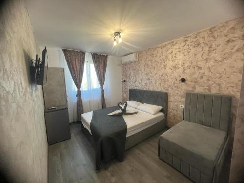 a small bedroom with a bed and a chair at Ana Boutique in Constanţa
