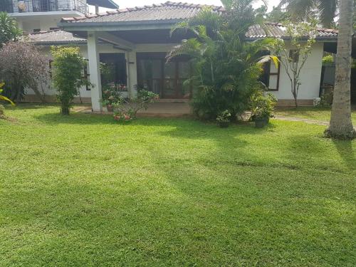 a house with a lawn in front of it at Dreamvillage in Dodanduwa
