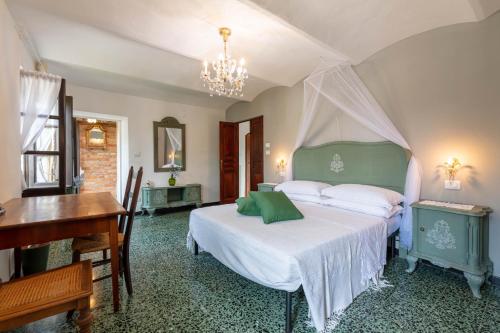 a bedroom with a bed and a desk and a piano at Piemonte Country House in Agliano Terme