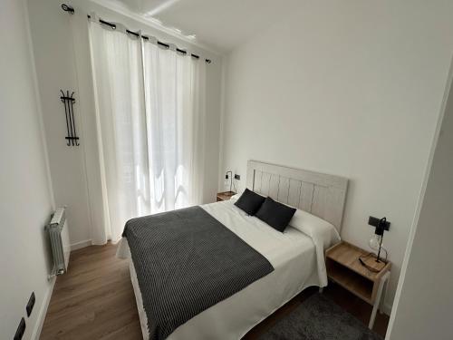 um quarto branco com uma cama e uma janela em Apartamento Vigo Centro Puerta del Sol em Vigo