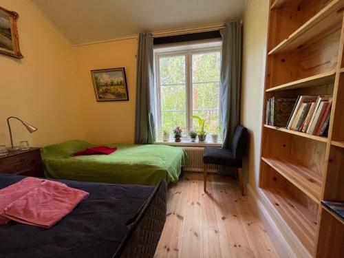 1 dormitorio con 2 camas, ventana y silla en Bed&Breakfast in nature 12 min from city free bikes en Estocolmo