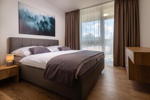 a bedroom with a large bed and a large window at TALBERG SK - Garage parking - Quiet place - Brand new apartments - Tále in Tale