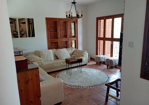 a living room with a couch and a table at Vavatsinia Panorama Cottage in Vavatsinia