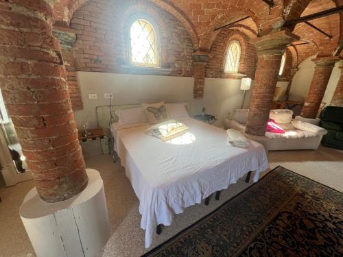 een slaapkamer met een bed in een bakstenen kamer bij B&B Antica cascina in Boretto