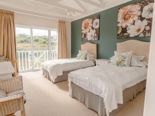 a bedroom with two beds and a balcony at Pinnacle Point Lodge 21 in Mossel Bay