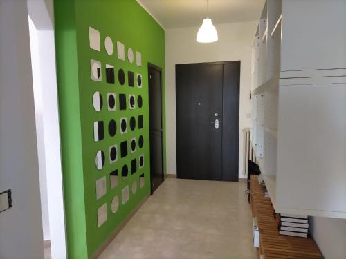 a hallway with a green wall and a black door at bellavista civico 100 in Pescara