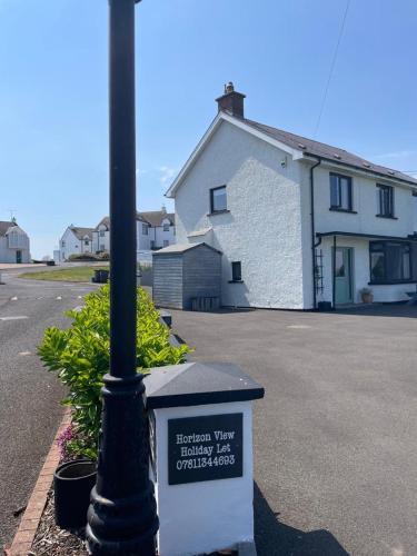 a street light with a sign next to a street at Horizon View Portstewart Tourist Board approved in Portstewart