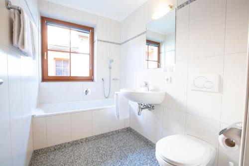 Un baño blanco con inodoro y lavabo. en Ferienwohnung Hochkrimml 19 __1-4, en Königsleiten