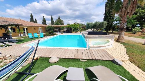 une piscine dans une cour à côté d'une maison dans l'établissement Villa spacieuse à Béziers avec piscine privée et jacuzzi, à Béziers