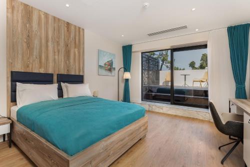 a bedroom with a bed and a desk and a window at Boulevard Hotel Batumi in Batumi