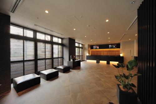Dormy Inn Premium Nagoya Sakae في ناغويا: غرفة معيشة فيها بيانو في مبنى
