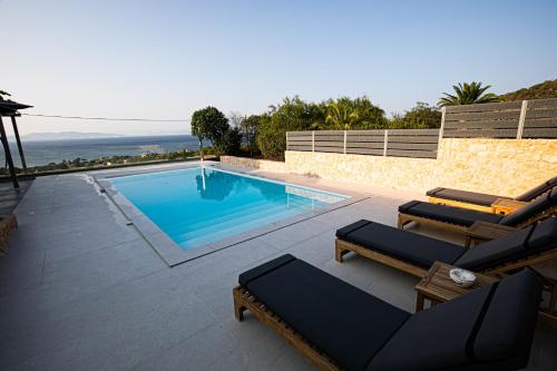 a swimming pool with chaise lounge chairs and a swimming pool at Pine House in Áyioi