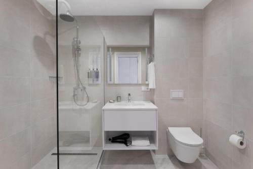 a bathroom with a shower and a sink and a toilet at Boulevard Hotel Batumi in Batumi