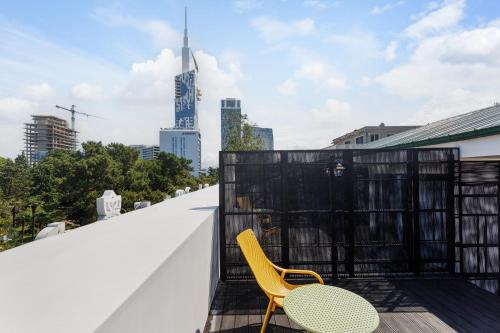 a yellow chair and a table on the roof of a building at Boulevard Hotel Batumi in Batumi