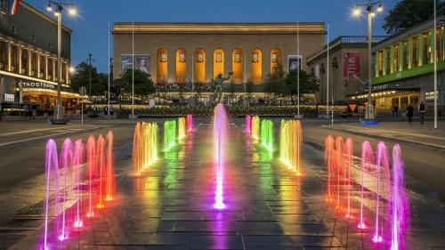 a fountain with colorful lights on a city street at Husbåten Vega 2 Göteborg City in Gothenburg