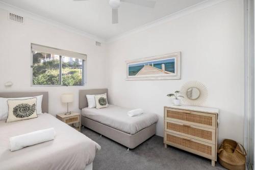 a bedroom with two beds and a desk and two windows at Bayview Towers 10 in Nelson Bay