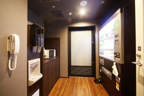 a room with a phone and a door with a screen at Dormy Inn Premium Nagoya Sakae in Nagoya