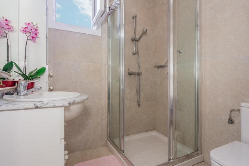 uma casa de banho com um chuveiro e um lavatório. em Villa Lidia em Cala Galdana