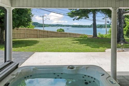a hot tub in a backyard with a view of the water at Lake Home, Dock, Fire Pit, Hot Tub, Game Room, Etc in Winchester