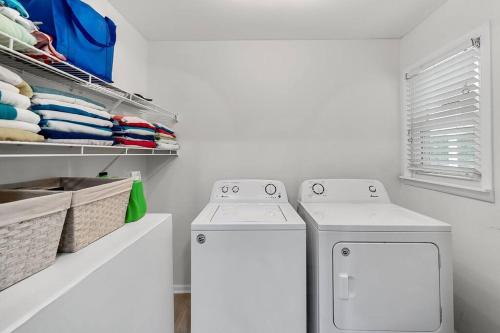 a laundry room with two washing machines and a window at Lake Home, Dock, Fire Pit, Hot Tub, Game Room, Etc in Winchester