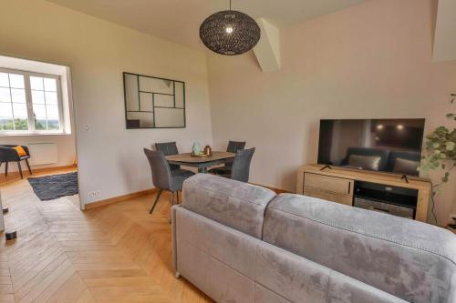 un salon avec un canapé et une télévision dans l'établissement Domaine Grand Piquecaillou - L'appartement Saint Emilion, à Saint-Maixant