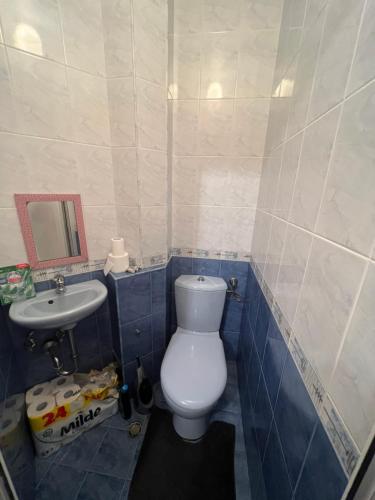 La salle de bains est pourvue de toilettes blanches et d'un lavabo. dans l'établissement Chaika Sea Apartment, à Varna