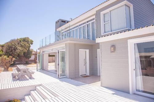 a house with a wooden deck in front of it at Bella Vista Yzerfontein - No loadshedding - Home away from home in Yzerfontein