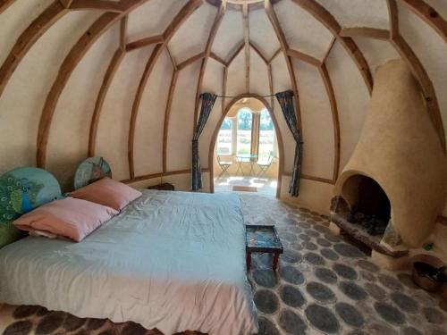 ein Schlafzimmer mit einem Bett in einem Zimmer mit einem Kamin in der Unterkunft SARL Verrerie Royale in Saint-Rémy-du-Plein