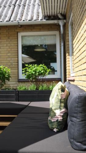 a backpack sitting on a couch in front of a window at Lovely villa at the foot of the Funen Alps in Fåborg