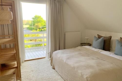a bedroom with a bed and a large window at Lovely villa at the foot of the Funen Alps in Fåborg
