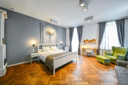 a bedroom with a bed and two green chairs at My Place Ferdinand in Cluj-Napoca