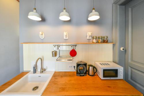 a kitchen with a sink and a microwave at My Place Ferdinand in Cluj-Napoca