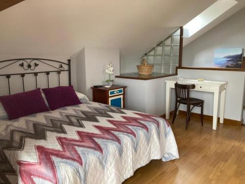 a bedroom with a bed and a desk and a table at Casa Encarnacion in Santo Emiliano