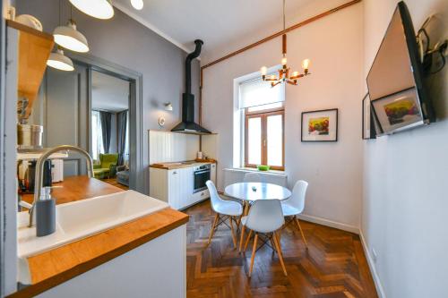 uma cozinha com uma mesa e um frigorífico branco em My Place Ferdinand em Cluj-Napoca