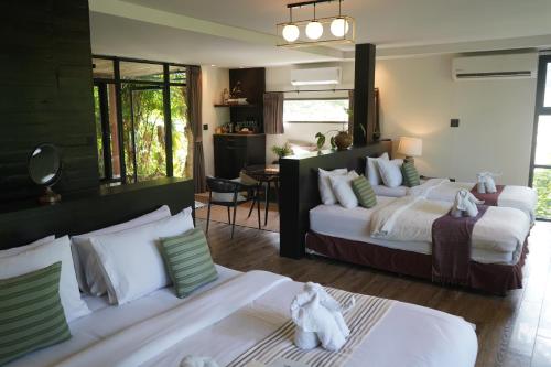 a large bedroom with two beds and a dining room at Kachonghills Tented Resort Trang in Trang