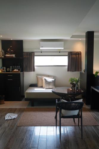 a living room with a bed and a table at Kachonghills Tented Resort Trang in Trang