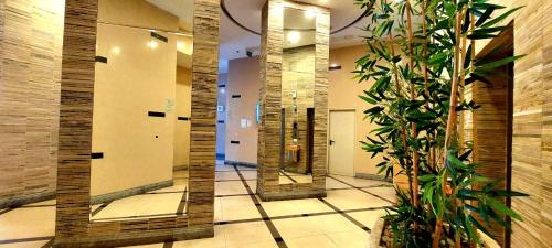 un couloir avec des miroirs et des plantes dans un bâtiment dans l'établissement apartments with separate kitchen by the sea, à Ashdod