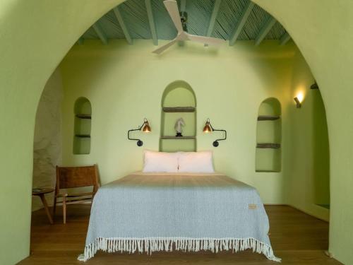 a bedroom with a bed with two arched ceilings at Aegean Garden Apartment in Kardhianí