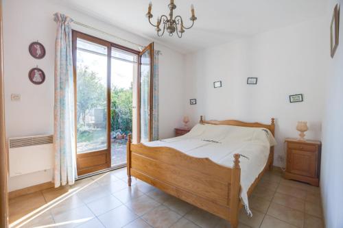 une chambre avec un lit et une grande fenêtre dans l'établissement Maison de charme à Agde avec jardin et terrasse, au Grau-dʼAgde